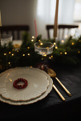 Christmas table setting with linen tableclothes, beautiful cutlery and dishes. Preparations for holiday dinner.