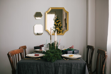 Christmas table setting with linen tableclothes, beautiful cutlery and dishes. Preparations for holiday dinner.