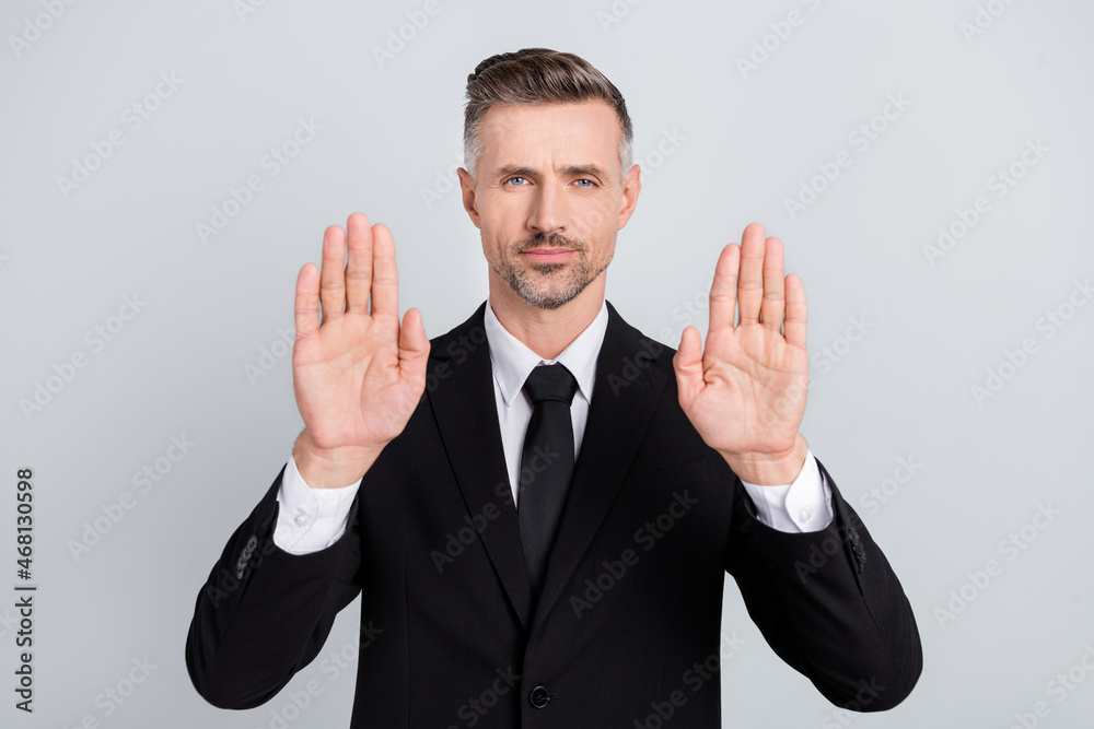 Poster photo of serious handsome young leader wear black jacket showing arms asking stop isolated grey colo