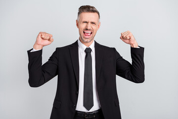 Photo of impressed lucky mature accountant dressed black suit rising fists successful achievement isolated grey color background