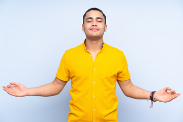 Asian handsome man over isolated background in zen pose