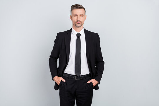 Photo of handsome serious mature boss assistant dressed black suit standing arms pockets isolated grey color background
