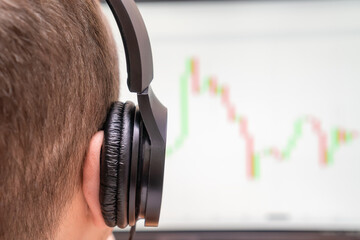 Close-up of a man with headphones looking at the monitor on red-green graphics, photos from the back