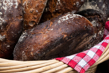 Rustic rye bread with raisins in wicker basket. Bakery stall at medieval festival. France.