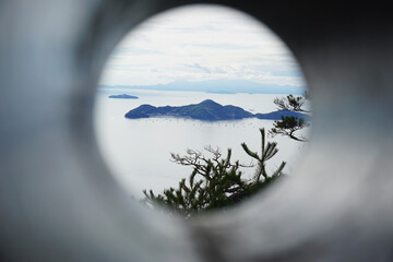 looking through binoculars at an island on a cloudy day