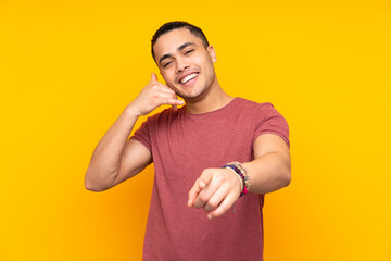 Asian handsome man isolated on yellow background making the gesture of being late