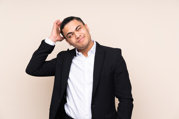 Asian business man isolated on beige background having doubts and with confuse face expression