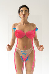 Naklejka premium Woman showing funny face while holding glass with drawing hairy unshaven female armpits