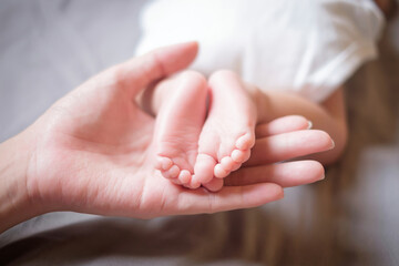Two baby foot on mother hand. Focus at foot finger.