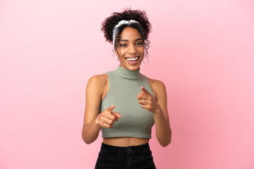 Young latin woman isolated on pink background surprised and pointing front