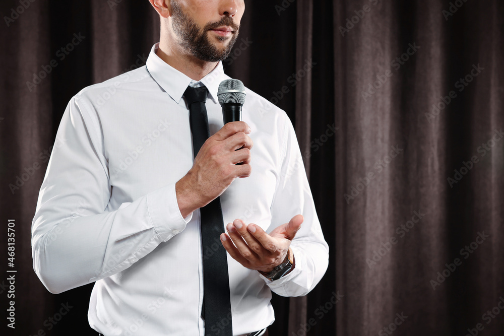 Wall mural motivational speaker with microphone performing on stage, closeup