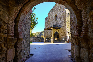 Fototapeta na wymiar View of the medieval church from the gate of the arched wall. Buitrago de Lozoya Madrid.
