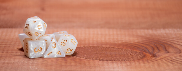 Set of role playing white dices on a gaming table made of wood: banner for Dungeons and Dragons role-playing games with place for text
