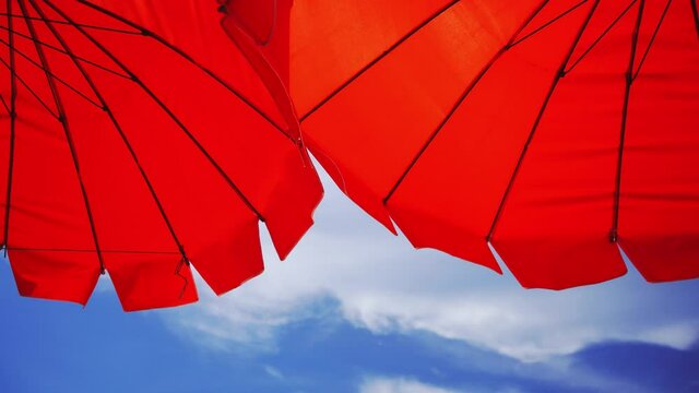 Red beach umbrella and blue sky. Summer beach vacations