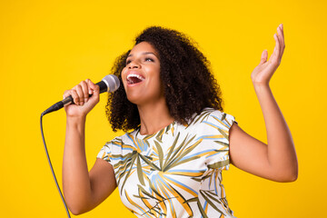 Profile side photo of young excited afro girl sing song karaoke celebrity isolated over yellow...