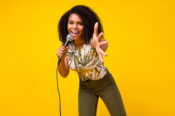 Photo of young cheerful afro girl star stage concert song microphone isolated over yellow color background