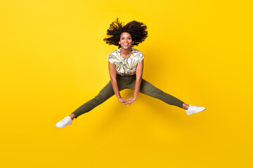 Full size photo of young excited afro girl have fun jump up energetic isolated over yellow color...