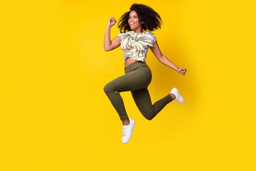 Fototapeta na wymiar Full body profile side photo of young afro lady go run jump hurry look empty space isolated over yellow color background