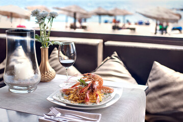 Almuerzo en chiringuito. Espaguetis fruto di mare en la playa. Comida en verano.