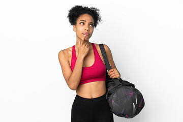 Fototapeta na wymiar Young sport african american woman with sport bag isolated on blue background having doubts while looking up