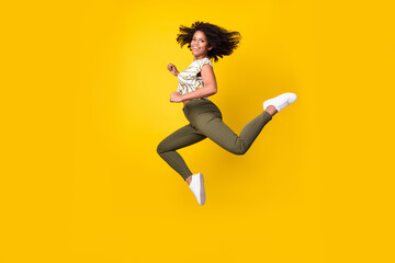 Fototapeta na wymiar Full size profile side photo of young afro girl jump runner carefree discount isolated over yellow color background