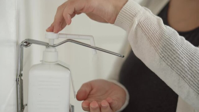 Close Up Young Pregnant Woman Treats Disinfects Hands With Antiseptic Before Medical Control On Hospital. Visit Gynecologist Doctor At Clinic. Examine Expectant Belly Baby Mother Healthcare Check Up