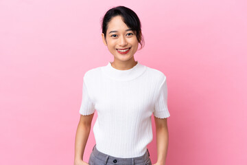 Young Vietnamese woman isolated on pink background laughing