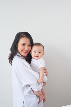 Portrait of a beautiful mother smiling with her baby in bedroom