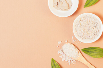 Natural cosmetic clay and sea salt on brown background
