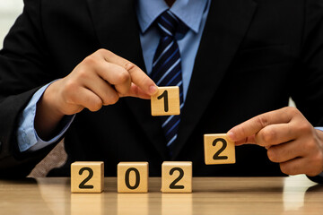 Businessman who looks forward confidently and turns calendar dates into years 2021, the concept of...