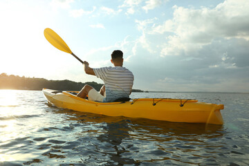 Handsome man kayaking on river, back view. Summer activity