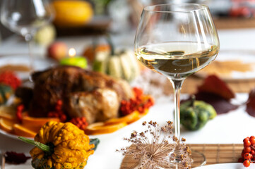 Thanksgiving celebration traditional dinner table setting food concept with wine glass and roasted turkey
