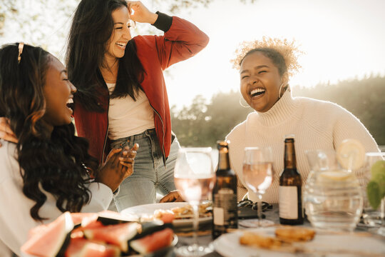 Cheerful female friends laughing while enjoying party