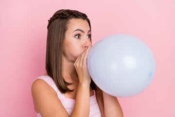 Photo of funny funky positive happy young woman blow air balloon celebrate holiday isolated on pink...