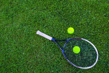 tennis racket and ball on grass