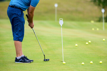 golfer putting a ball into the hole