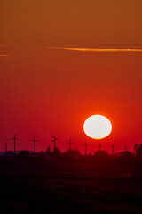 sunset and silhouettes of voltage poles