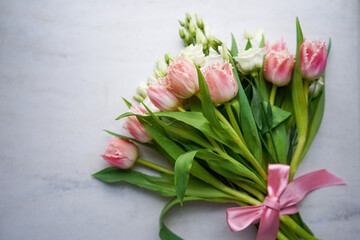 Top view of pink tulips bouquet with pink ribbon. International Women's Day.