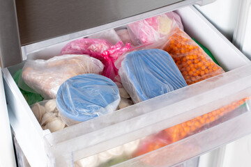 Frozen food in the freezer. Frozen vegetables, soup, ready meals on the freezer shelf