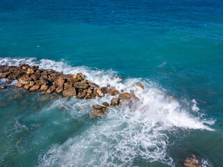 Aerial view of sea waves crashing of big stones