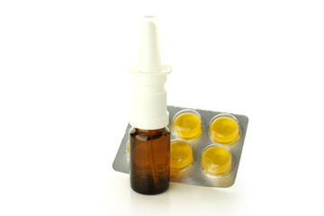 Blank bottle of nasal spray and pills isolated on white background
