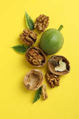 Walnuts with nut peel on yellow background