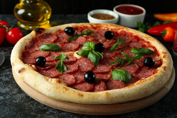 Concept of tasty food with Salami pizza on dark background