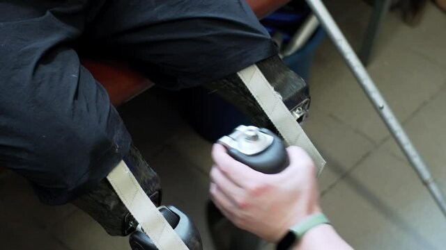 A medical engineer hands checking the artificial bionic leg prothesis device unscrewing its parts. Maintenance of modern bionic legs prothesis for man living with a disability with amputated legs