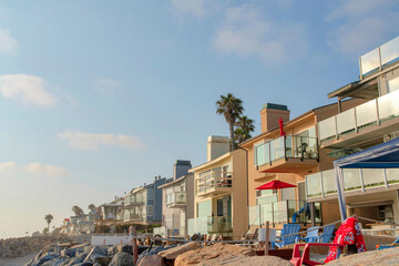 Row of beach house buildings with lounge chairs outside at Oceanside, California