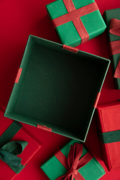 Open festive christmas present box on a red background. Flat lay, top view