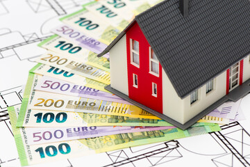 model home standing on bundles of Euro currency