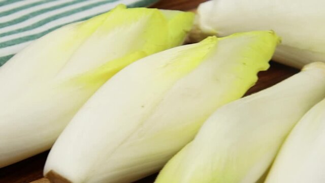 plusieurs endives crues sur une planche &agrave; d&eacute;couper