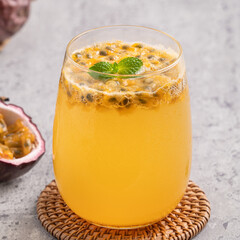 Delicious juicy passion fruit with sparkling juice on gray table background.