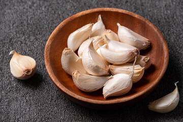 Fresh garlic cloves on black table background.